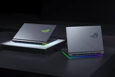 Three-quarter perspective view of the ASUS ROG Strix G16 laptops showcasing their cyber-themed chassis designs and bright under-glow RGB lightbars.